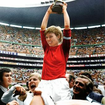 Eine Frau hält in einem Fussballstadion Pokal in die Luft