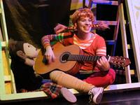 Man sieht Pippi Langstrumpf mit Gitarre.