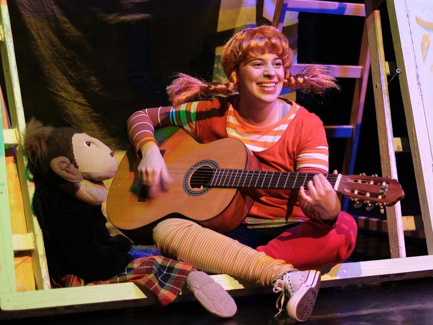 Man sieht Pippi Langstrumpf mit Gitarre.